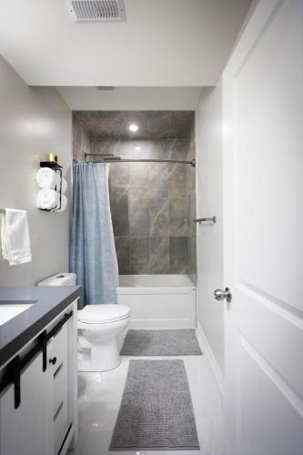 a white bathroom with a toilet and a shower at Cozy Cove Retreat, Private Suite with Separate Entrance Near Friday Harbour, Barrie & Lake Simcoe in Innisfil