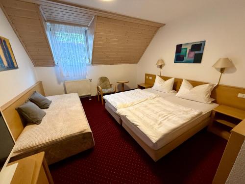a hotel room with two beds and a window at Landhotel am Mühlenwörth in Tauberbischofsheim