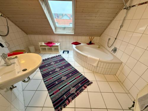 a bathroom with a tub and a sink at Landhotel am Mühlenwörth in Tauberbischofsheim