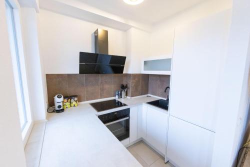 a small kitchen with white cabinets and a sink at Ferienwohnung Allegra in Heinsberg