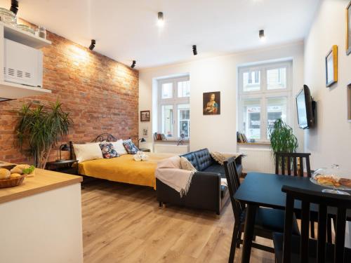 a room with a bed and a brick wall at Apartamenty Bydgostia Dworzec in Bydgoszcz