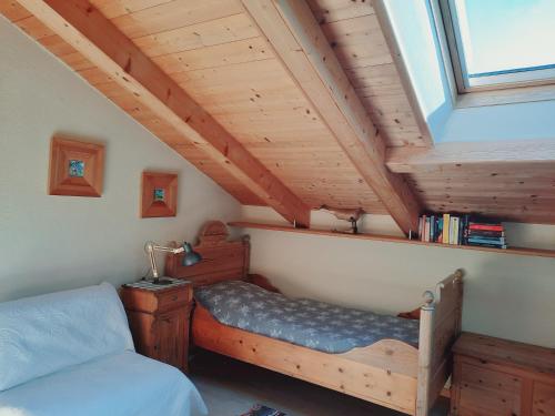 a bedroom with a bed and a window in a attic at Enzian in Sesto