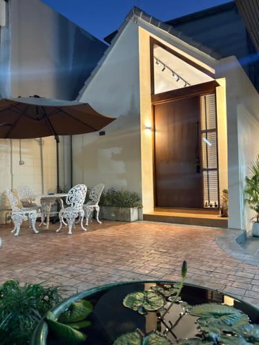a patio with a table and chairs and an umbrella at Morya House in Bangkok