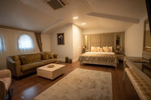 a living room with a bed and a couch at BANDIRMA PALAS OTEL in Bandırma