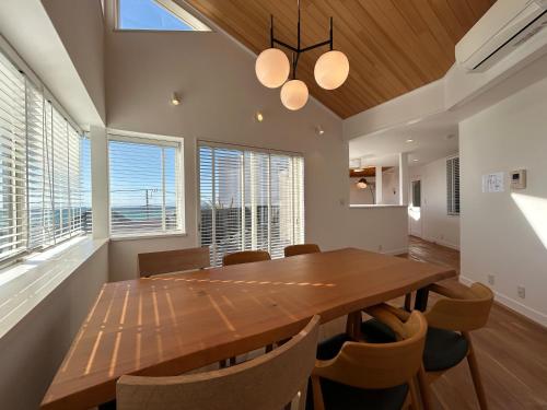 a dining room with a wooden table and chairs at Smile House Akiya in Hayama