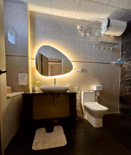 a bathroom with a sink and a toilet and a mirror at Chèrie Blueleaf in Jaipur