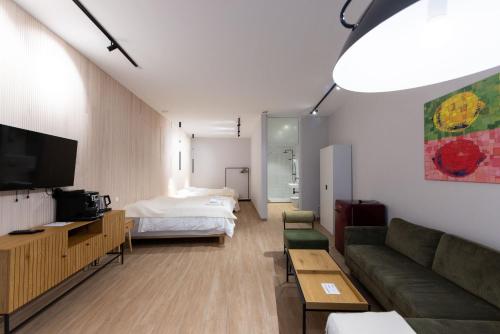 ein Wohnzimmer mit Sofa und Bett in der Unterkunft Hotel Allegra in Heinsberg