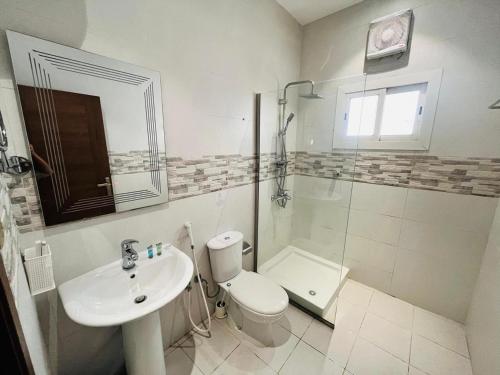 a bathroom with a toilet and a sink and a shower at فندق صها in Ash Shishah