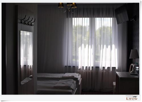 a room with two beds in front of a window at Lwów in Chełm