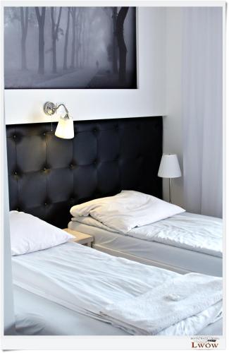 two beds in a bedroom with a picture on the wall at Lwów in Chełm