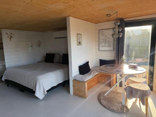 a bedroom with a bed and a table and a window at R&M Boutique in Lijnden