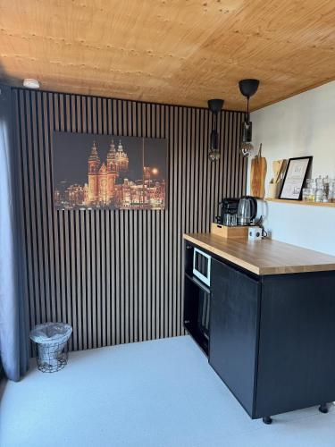 a kitchen with a black and white striped wall with a tv at R&M Boutique in Lijnden