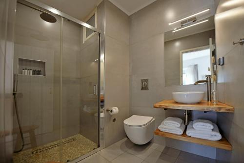een badkamer met een douche, een toilet en een wastafel bij NESEA VIEW Boutique Apartments in Hydra