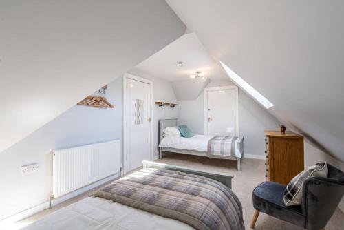 a attic bedroom with a bed and a chair at Lonan Country House and Gardens in Taynuilt