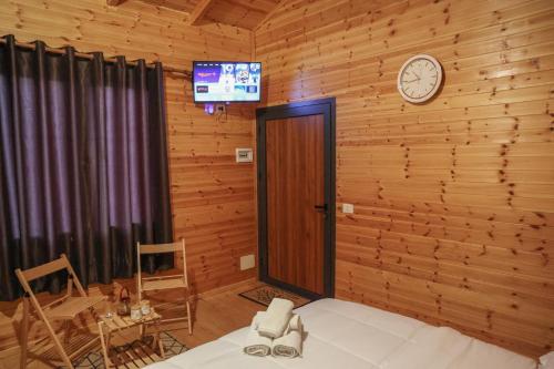 a room with a clock on a wooden wall at Berat Hill Cabins in Berat