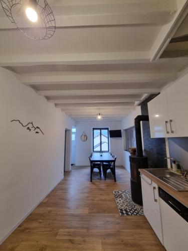 a kitchen with a table in the middle of a room at Gîte 6 personnes Chez Max in Nébouzat