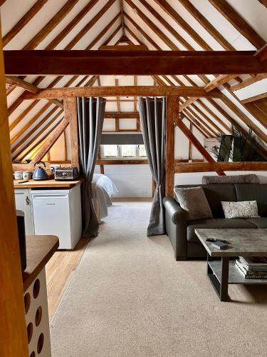a living room with a couch in a attic at The Granary in Hurstpierpoint