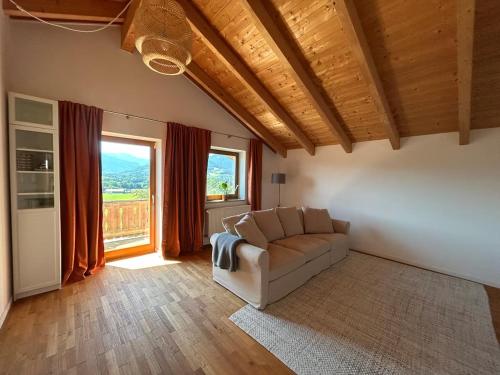 a living room with a couch and a large window at Servus Chiemgau - Große Wohnung mit Bergblick in Frasdorf