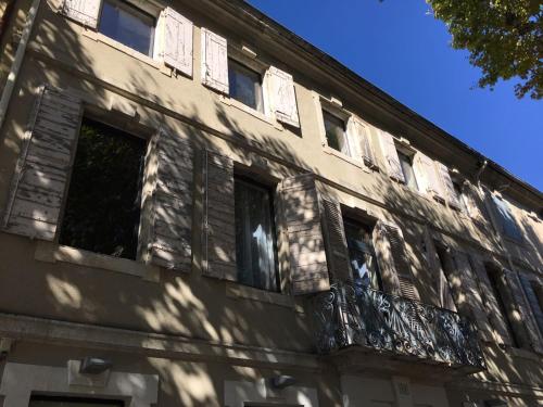 an old building with windows and a balcony at Appartement des carassins in Saint-Rémy-de-Provence