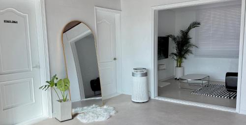 a mirror in a white room with a living room at 휘게스테이 in Sejong