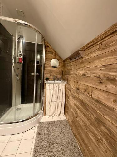a bathroom with a shower and a wooden wall at Valhalla Hytte in Oppdal