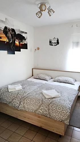 a bedroom with a large bed with two pillows at Apartments Happy Day in Karlobag
