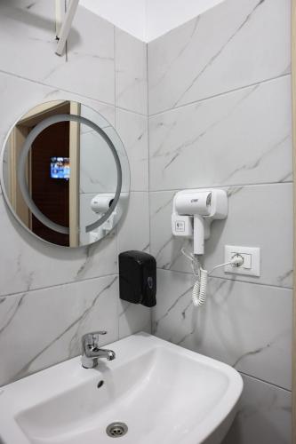 a white bathroom with a sink and a mirror at Berat Hill Cabins in Berat