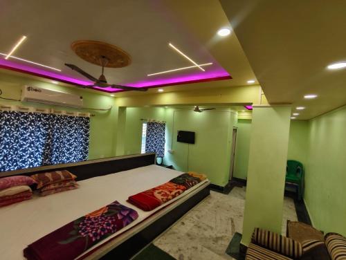 a bedroom with a large bed with purple lights at Maa durga lodge in Navadwīp
