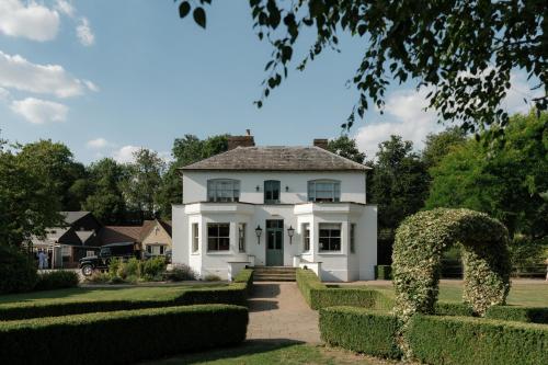 an image of a white house with hedges at Tewinbury Farm Hotel in Tewin