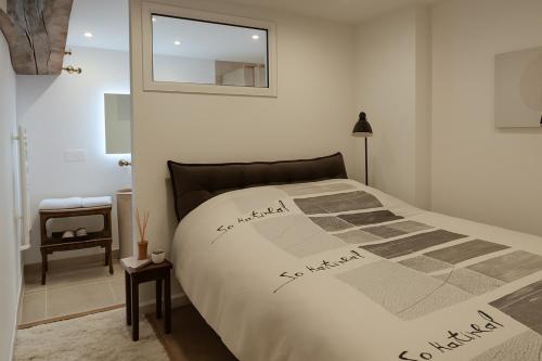 a bedroom with a bed with a comforter on it at La Maison des Templiers in Couches
