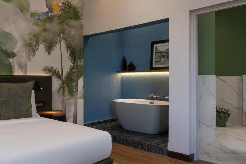 a bedroom with a bed and a tub in a bathroom at Fairview Hotel Nairobi, Vignette Collection by IHG in Nairobi