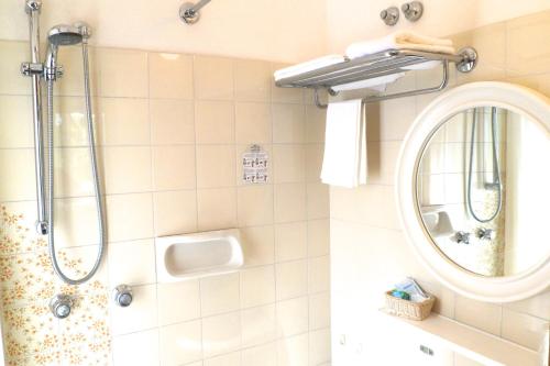 uma casa de banho com um chuveiro e um espelho. em B&B Domus Mea em Cesenatico