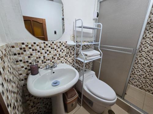 a bathroom with a sink and a toilet and a mirror at Magnolia Andina Hostel in Cusco