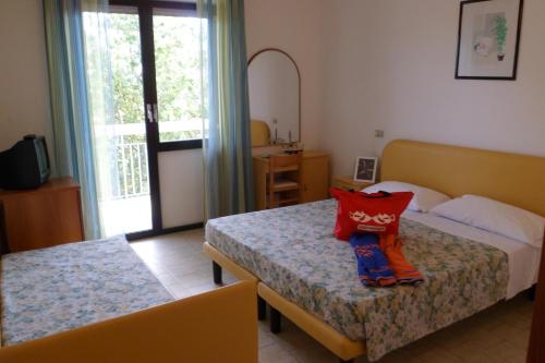 a hotel room with two beds and a window at B&B Domus Mea in Cesenatico