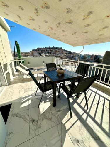 a table and chairs on a balcony with a view at Vista Kavala Center in Kavála
