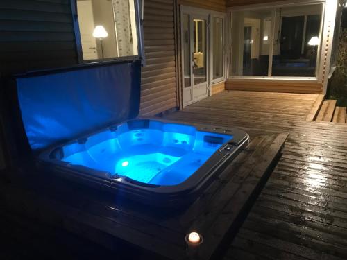 a jacuzzi tub on a porch at night at Ferienhaus Valle-Sjötomt Borshult in Diö