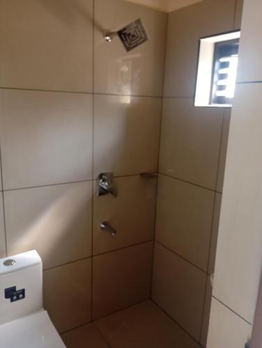 a bathroom with a shower with a toilet at PURAYIL Rooms in Kozhikode