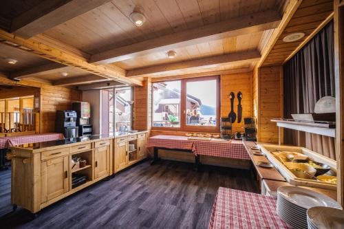 a kitchen with wooden cabinets and a large window at Hotel Emeraude in Peisey-Nancroix