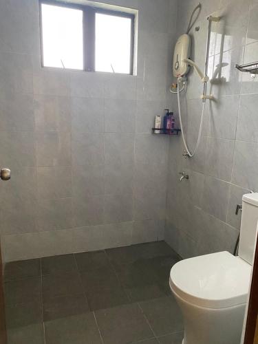 a bathroom with a toilet and a shower at La villa June by Juniar Place in Kampong Ulu Pegoh