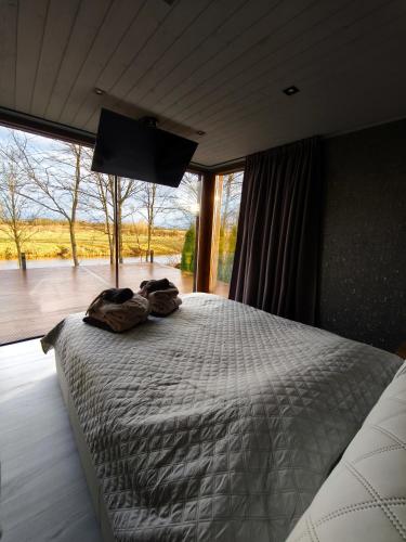 a bedroom with a bed with a flat screen tv at KotkaPesa in Vihtra