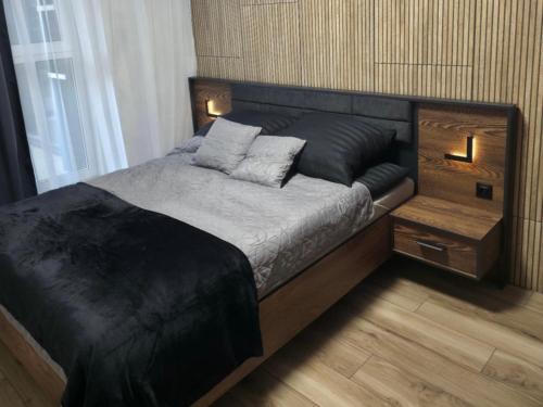 a bedroom with a black bed with two pillows at Mostique Spa Apartment with Jacuzzi in Gdańsk