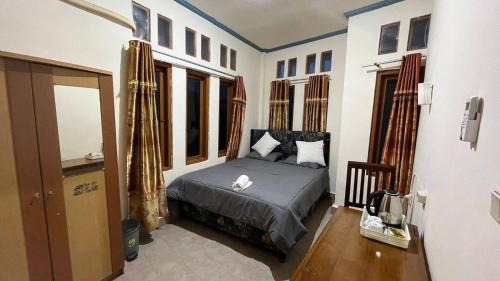 a bedroom with a bed in a room with windows at Chik Nories in Labuan Bajo
