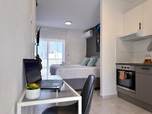 a kitchen with a laptop on a glass table in a room at D' Suites Holiday Apartments in Il-Gżira