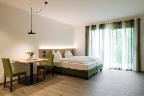 a bedroom with a bed and a table and a desk at Villa Rosengarten Guesthouse in Merano