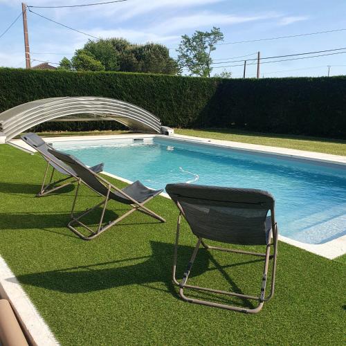 two lawn chairs sitting next to a swimming pool at L'OUSTAL D'ADELE proche Canal du Midi et Moissac in Saint-Nicolas-de-la-Grave