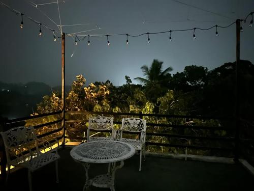 a patio with two chairs and a table and lights at Mantara in Matara