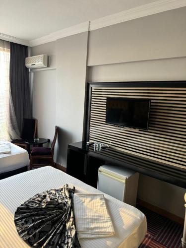 a hotel room with a bed and a flat screen tv at Ankara Efes Otel in Altındağ
