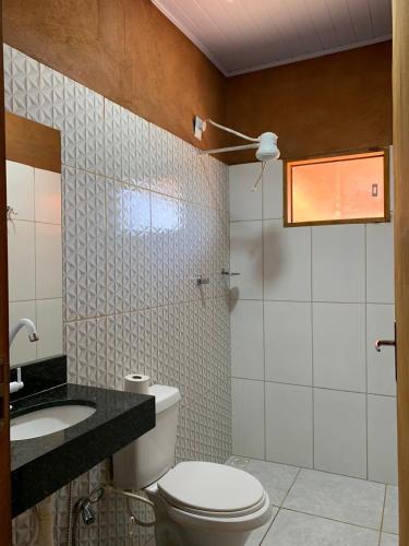 a bathroom with a toilet and a sink at Recanto do Vale in Pirenópolis