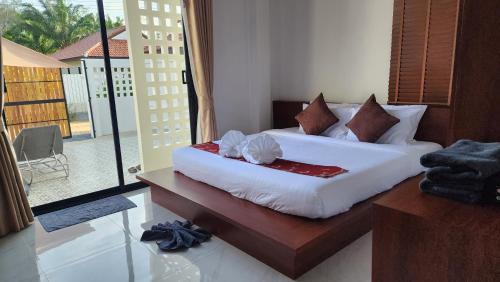 a bedroom with two beds and a large window at Pana Villa Koh Lanta in Ban Ai Dao