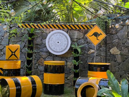 a group of yellow and black barrels next to a stone wall at Mantara in Matara